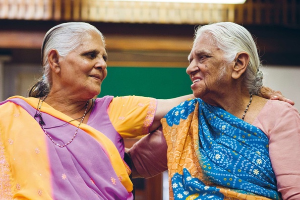 Two elderly South Asian ladies arm in arm