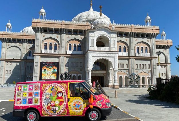 A picture of Lata's colourful transit van in front of the grand facade of Gravesend Gurdwara