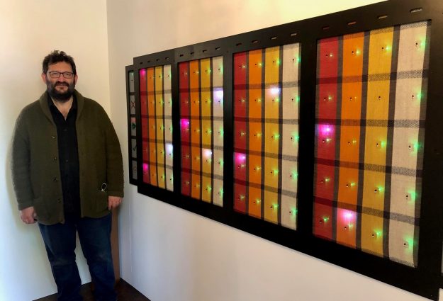 Picture of artist Mike Roberts next to his piece 'Woven 808', a woven version of the Roland 808