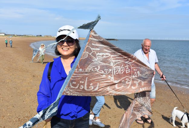 Picture of Simone Xue holding a flag for Beach of Dreams